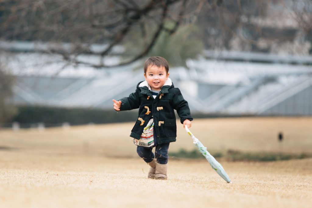 お気に入りの傘を持って嬉しそうに走る男の子